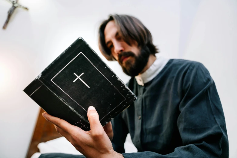 a person holding a cross and the name of the word on it