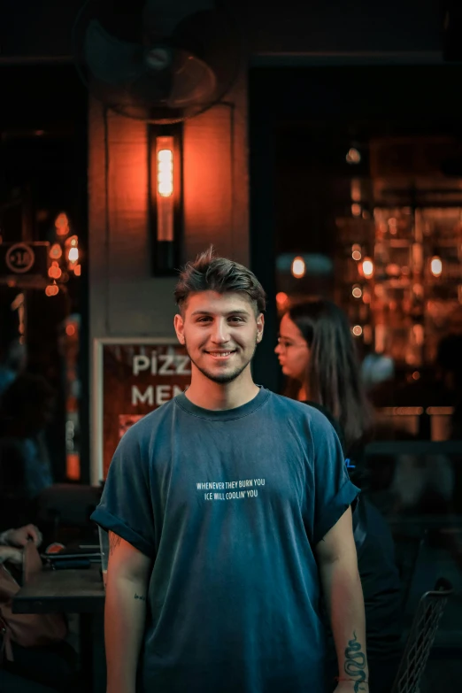 the man is standing in front of a restaurant while smiling
