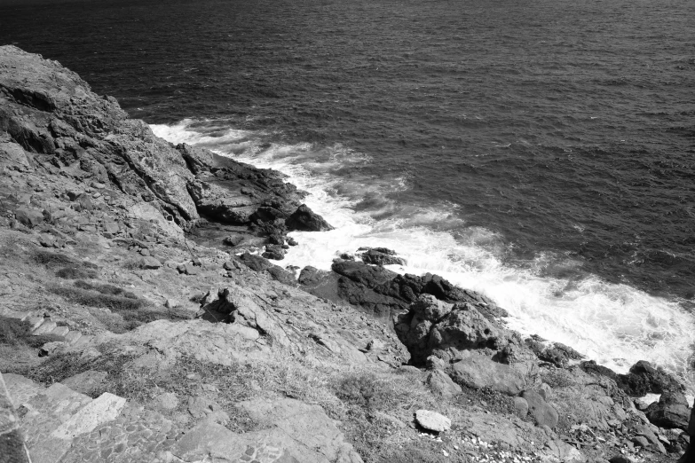 a black and white po of the ocean with waves crashing in to shore