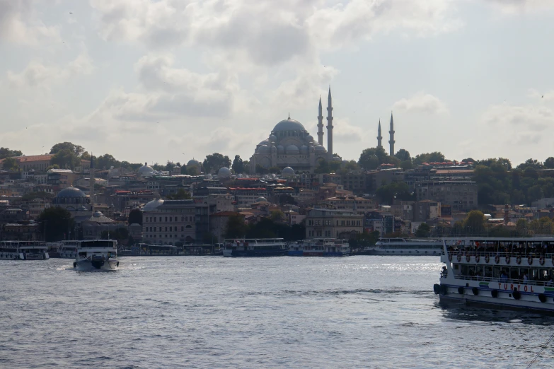 a group of boats traveling across a river next to a city