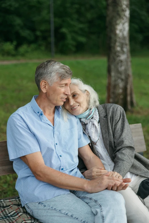 an older couple sitting on a park bench together