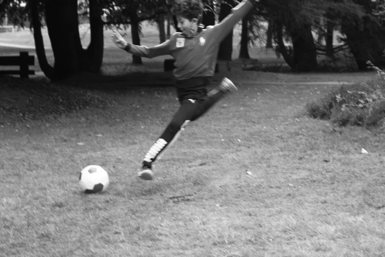 a man kicking a soccer ball around a field