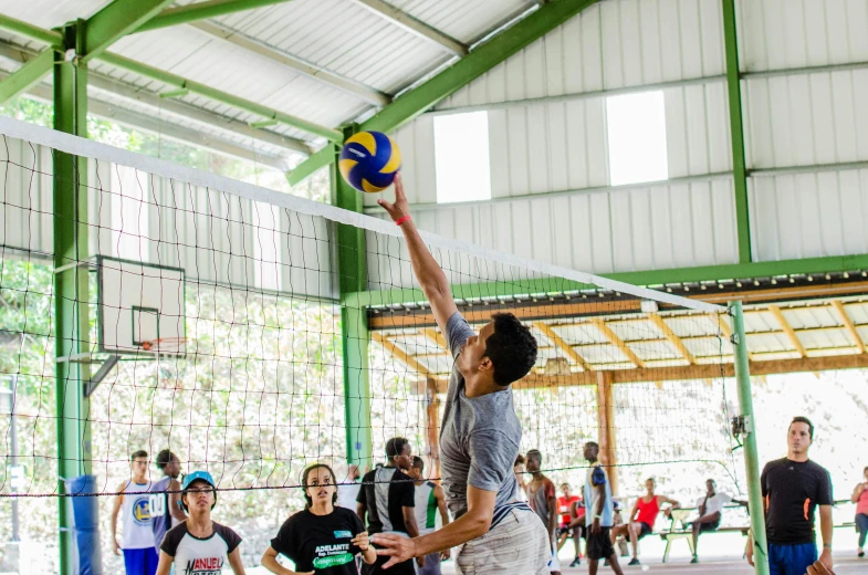 a man reaching up to hit a volley ball in the air