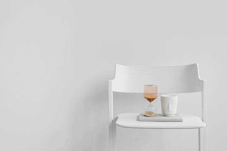 a white chair has cups and a tray on it