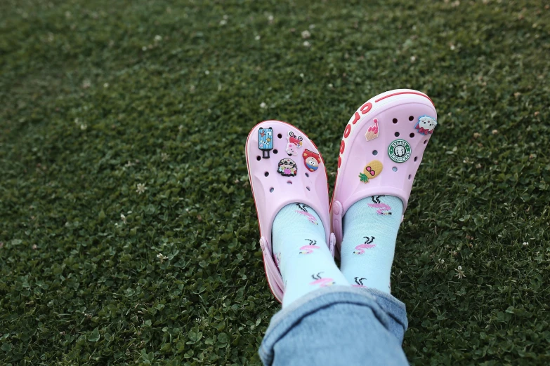 a pink pair of slippers is wearing blue jeans and a hello kitty hat