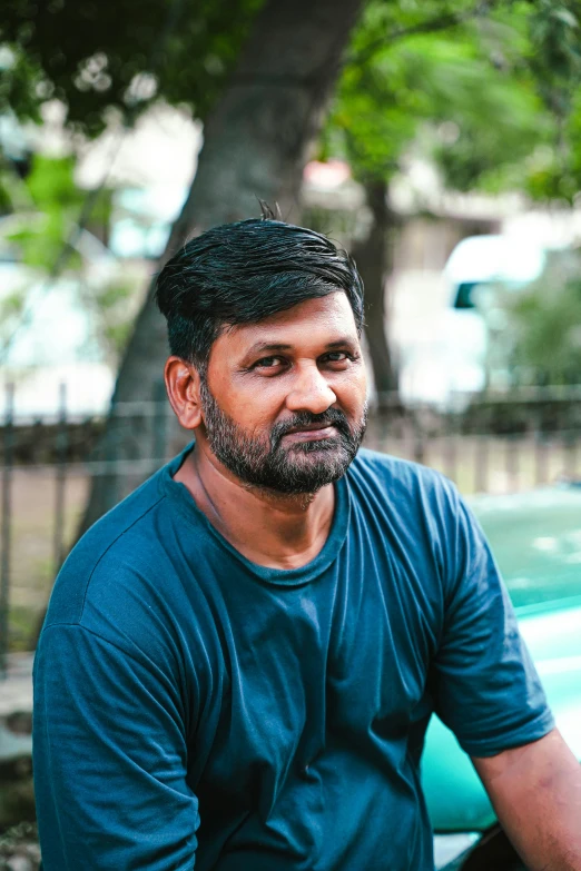 a man sitting down in front of a tree