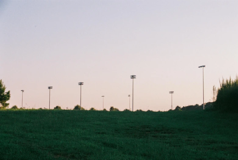 an empty field with a row of street lights