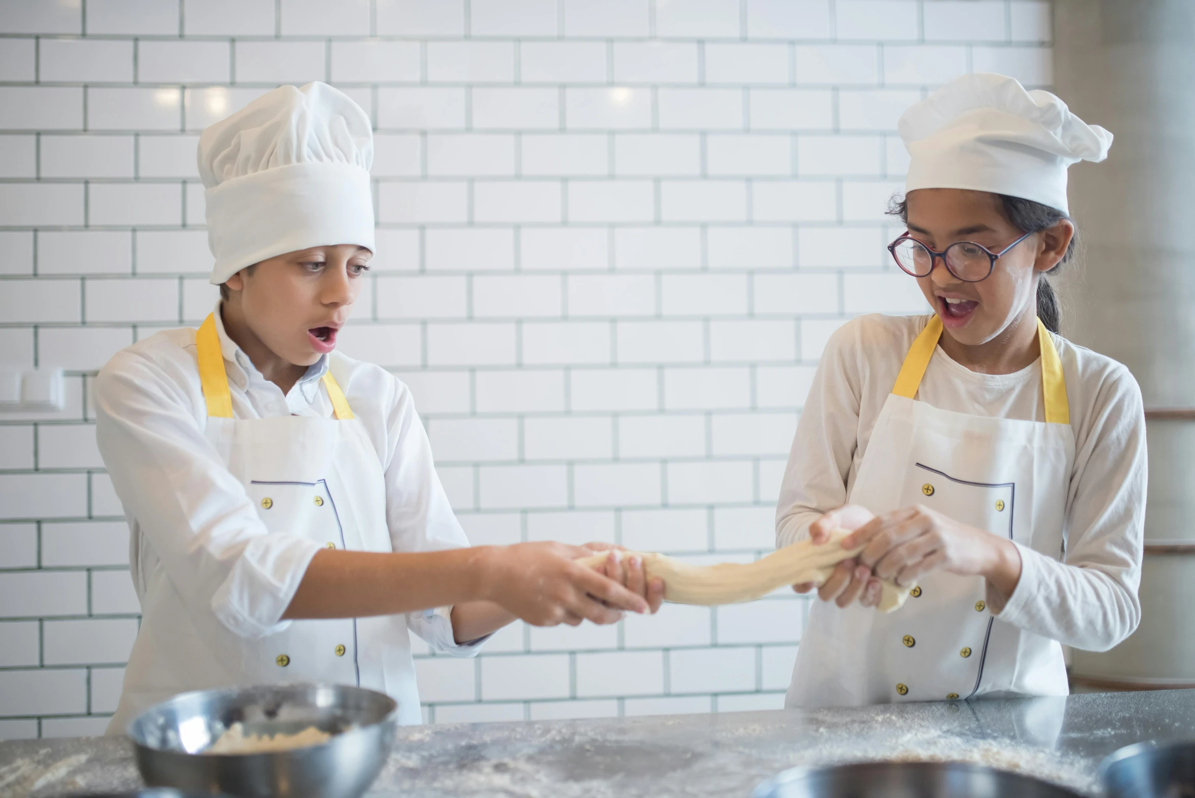 two people who are in the kitchen cooking