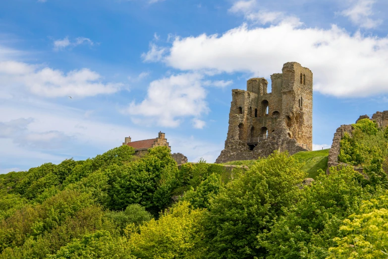 an old castle tower on top of a hill