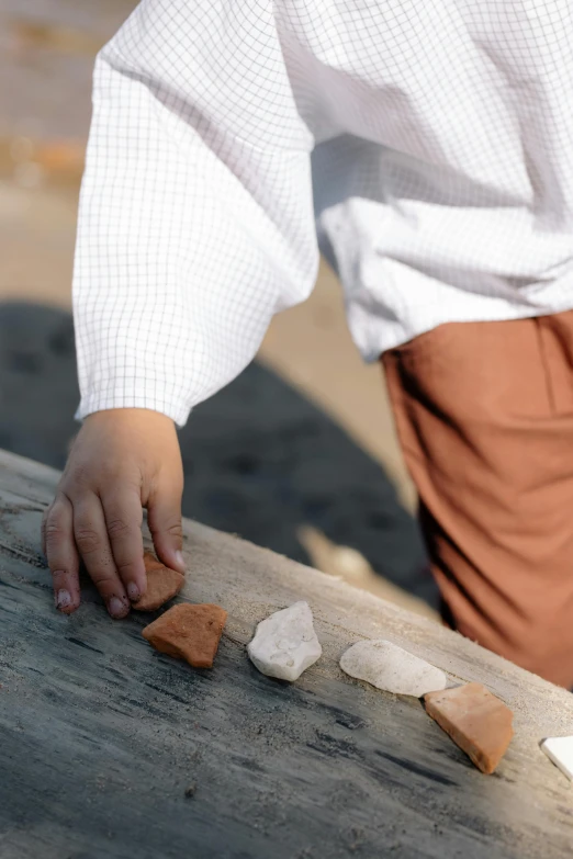 a person in white shirt using wood cutter to cut heart shapes