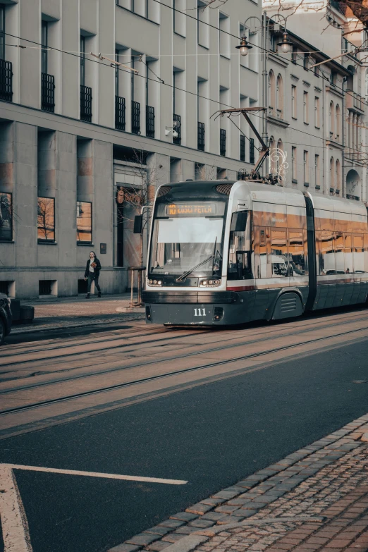 a tram moving past a bus stop on a street with no cars