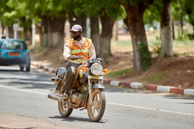 the man is riding his motorcycle down the street