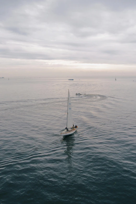 a boat sailing in the ocean on a cloudy day