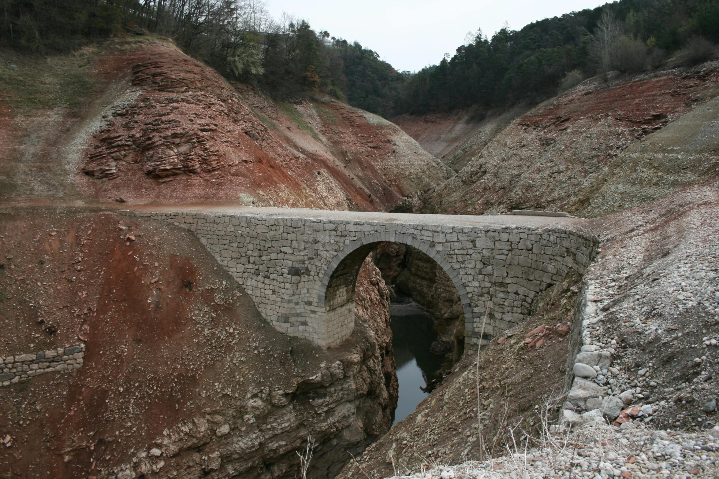 an old bridge with a small creek running through it