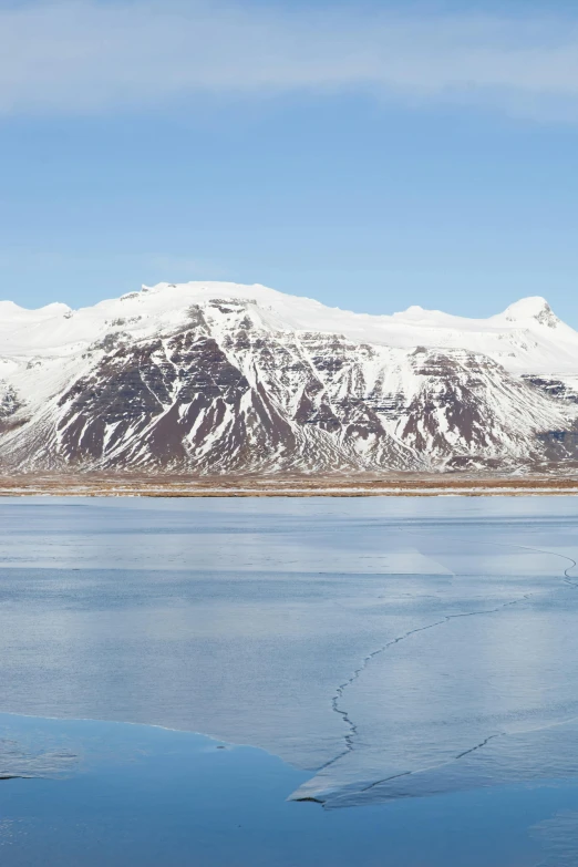 a long view of a snowy mountain on the water