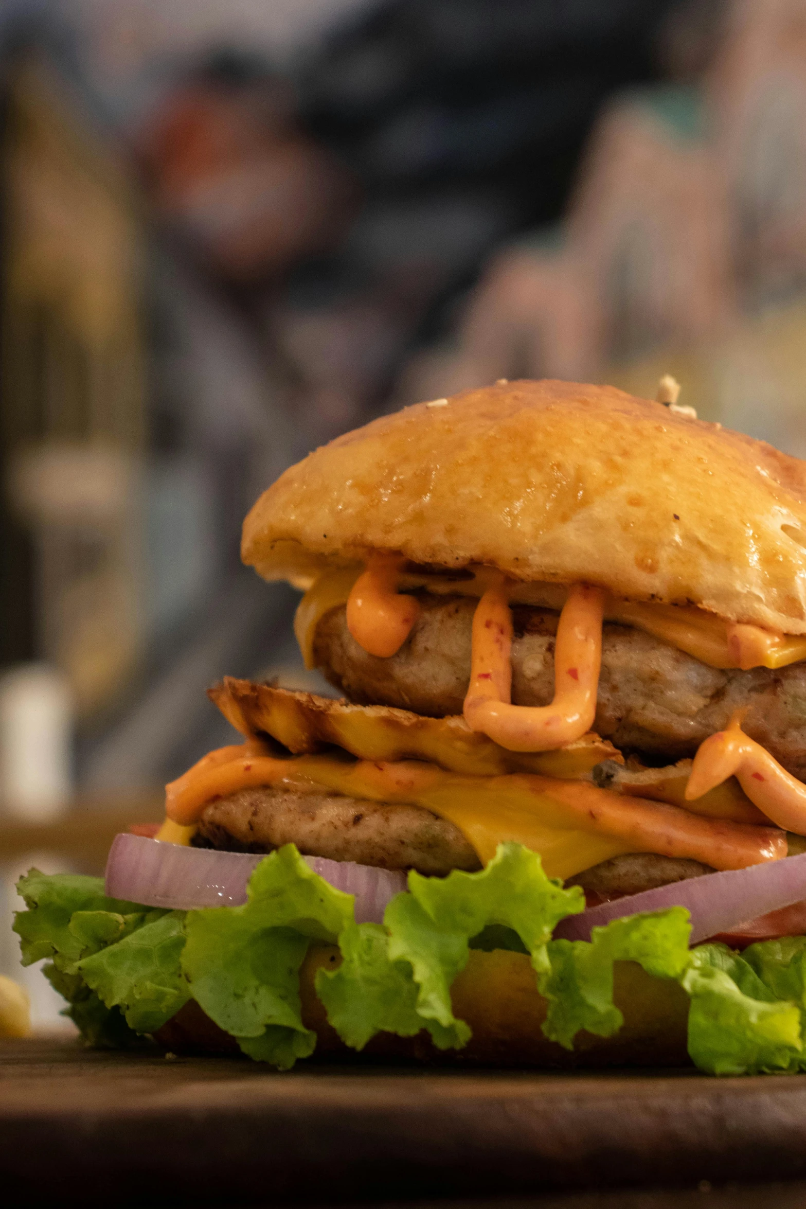 burger with toppings sitting on a wooden table