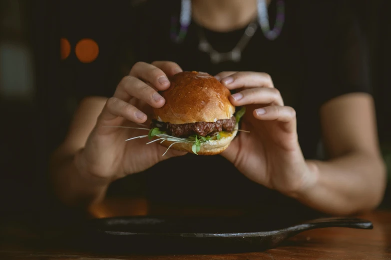 a close up of a person holding a cheeseburger