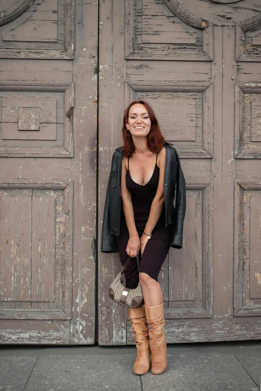 a woman leaning on the side of a building with her legs hanging up in front of it