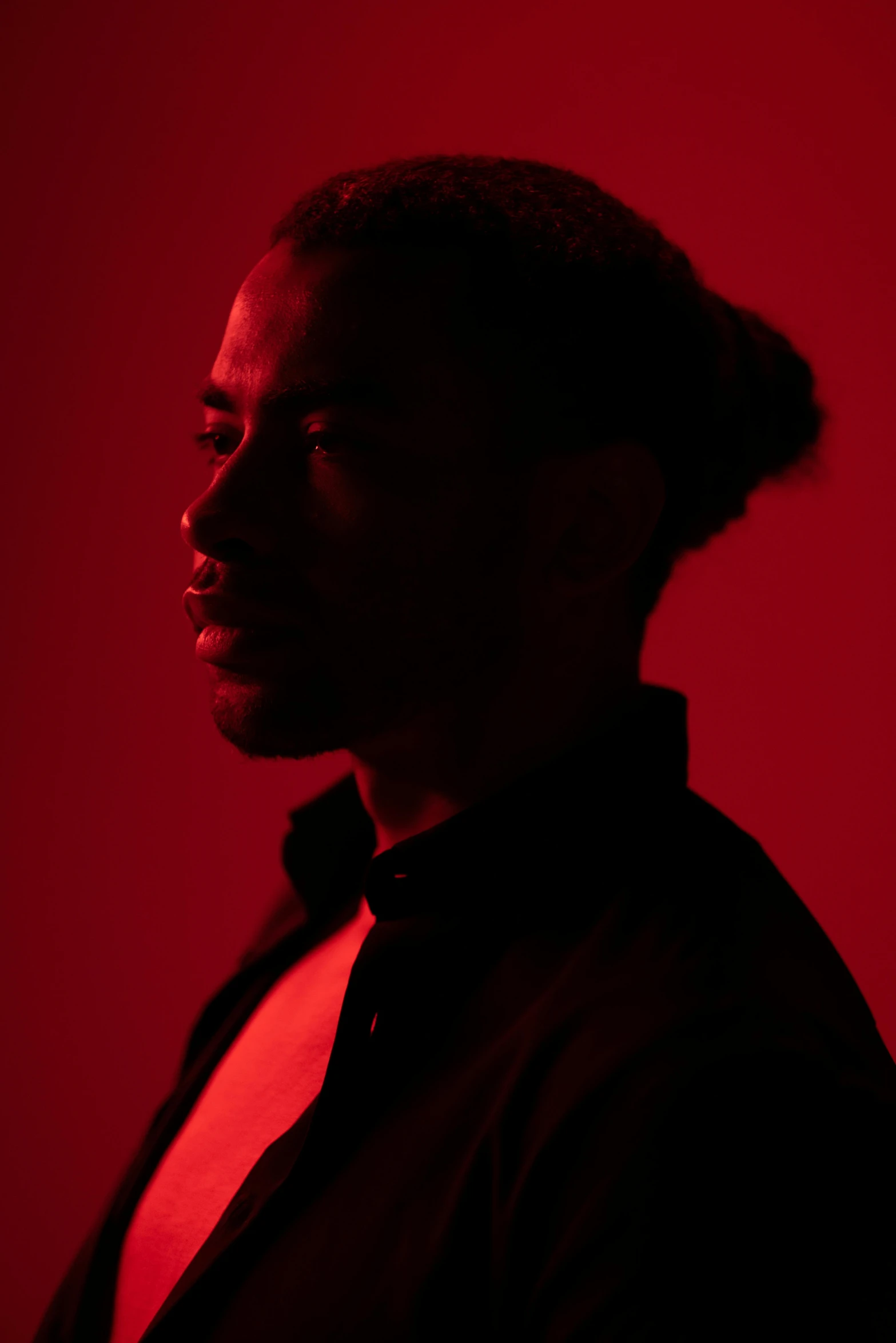 a man standing in a red room with his eyes closed