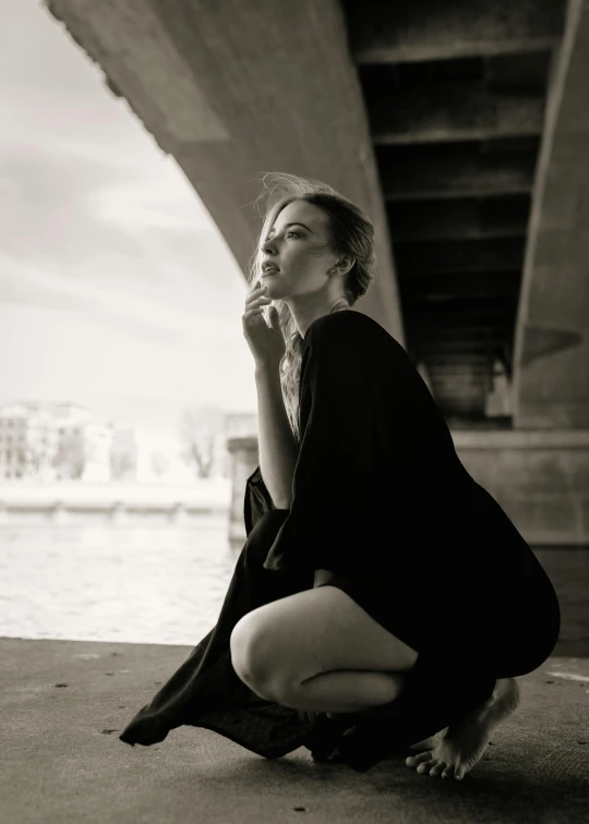 a woman is posing in front of a river