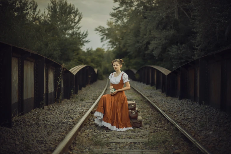 a woman standing on a train track with a suitcase