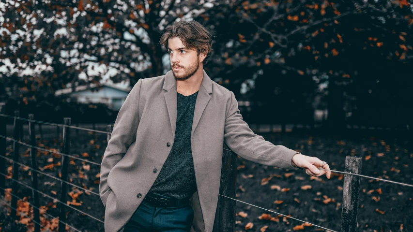 a man is leaning on a fence