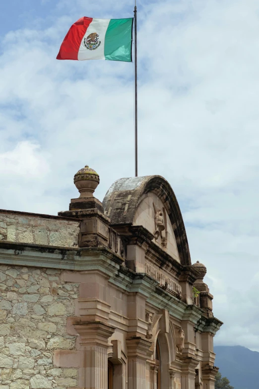 an italian and mexican flag flying on top of a building