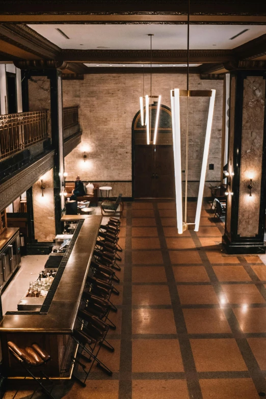 a view of a long kitchen with chandeliers on both sides