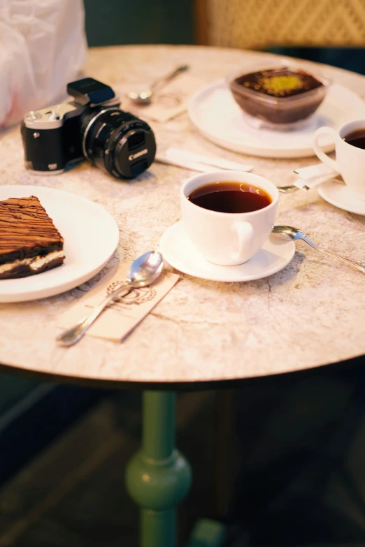 a table set with plates, cups, and utensils for dessert