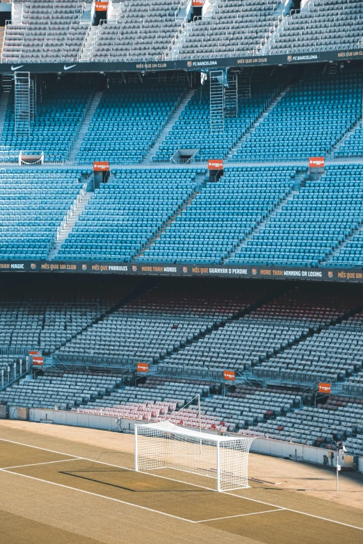 a soccer field and goalie posts with rows of empty seats