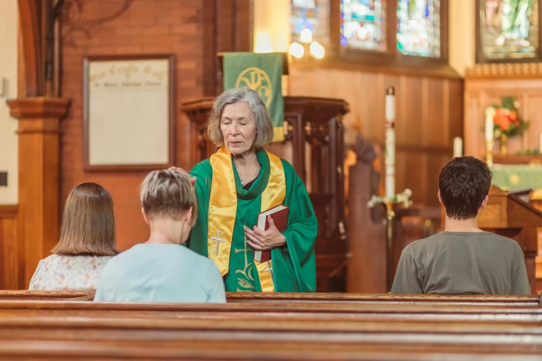 a woman standing in the alter of a church with other people