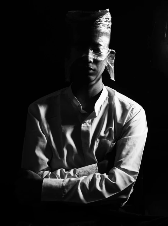 a man sitting next to a window in a dark room