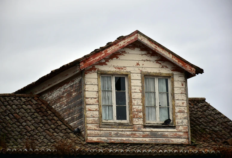 an old brick building with two white windows