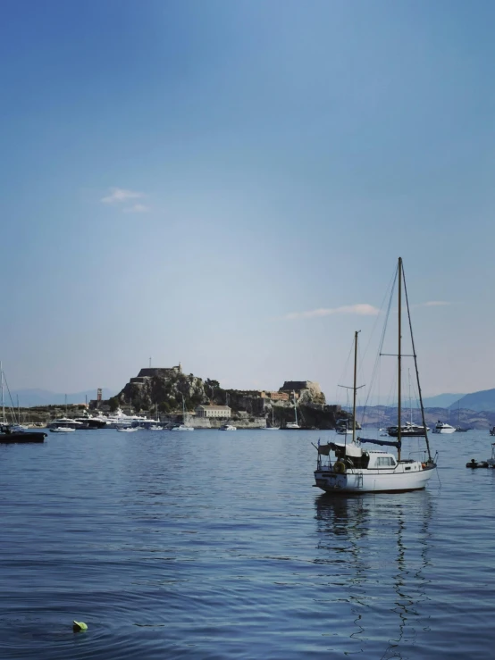 some boats sitting on the ocean near an island