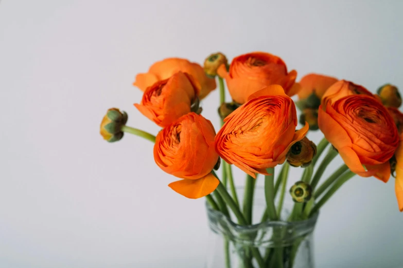 the small vase is holding orange flowers