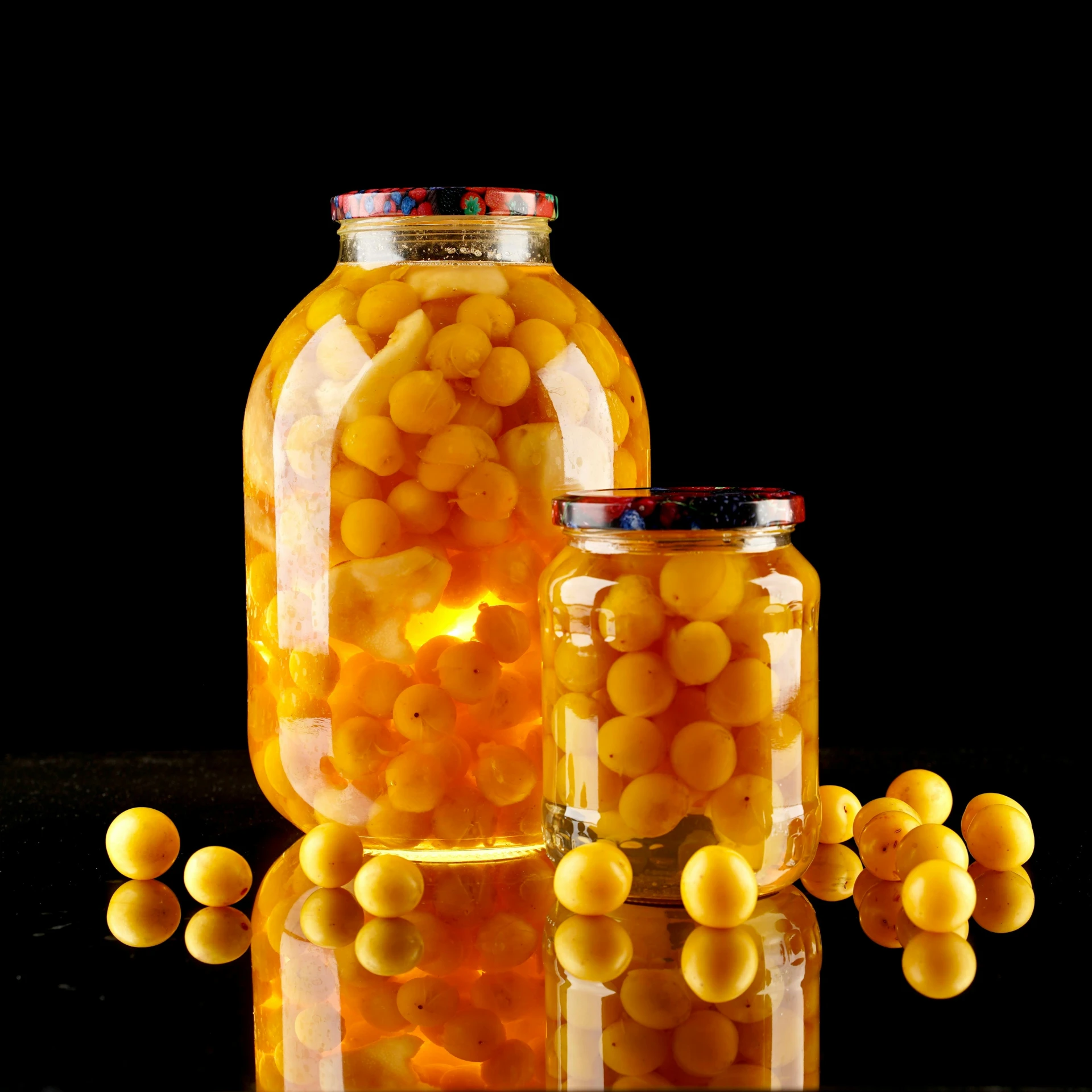 three jars are filled with yellow beans on a black table