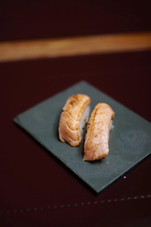 two cooked fish pieces on a plate near each other