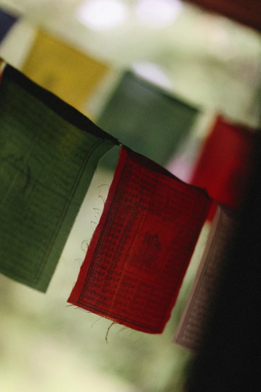 several square flags with various colors hanging in a row