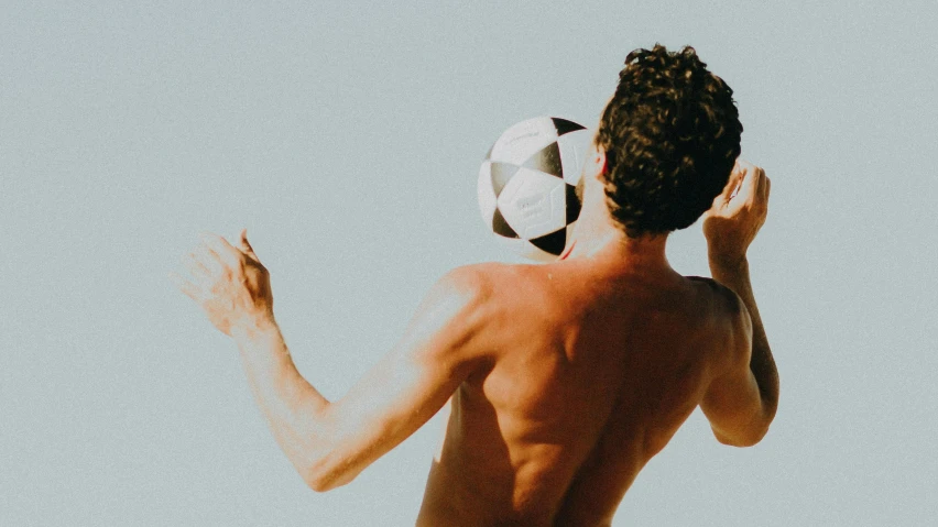 a young man is holding a soccer ball in his hand