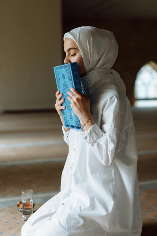 a woman in a white outfit sitting down while reading