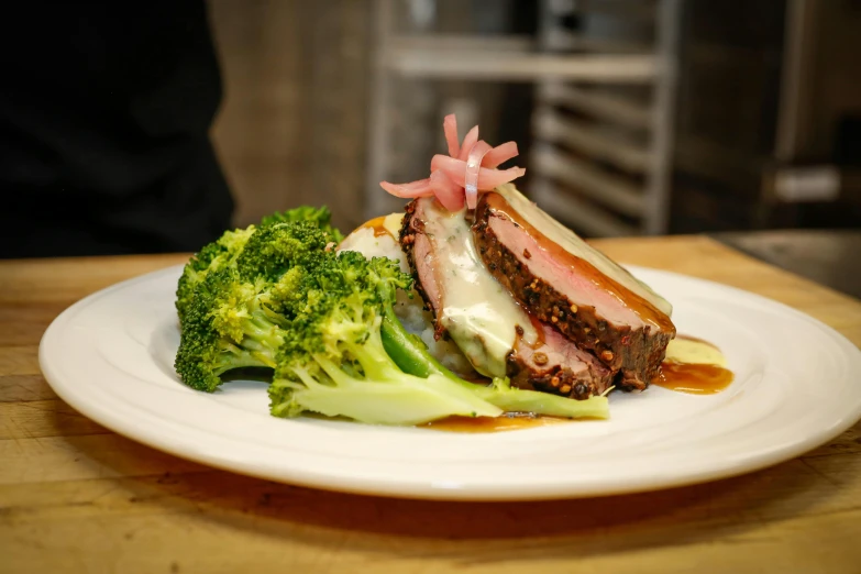 a white plate topped with meat covered in sauce and vegetables