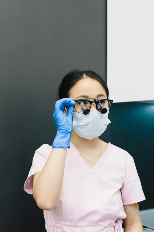 a woman wearing glasses and a surgical mask