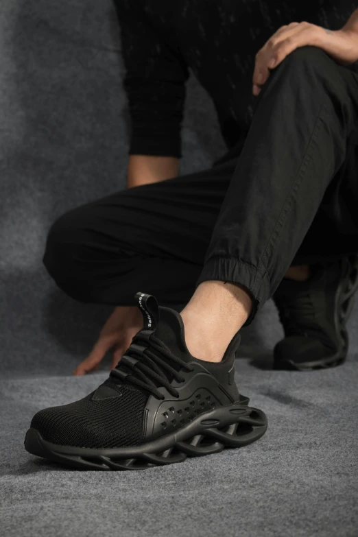 man in black jogging shoe tying up his sneaker shoes