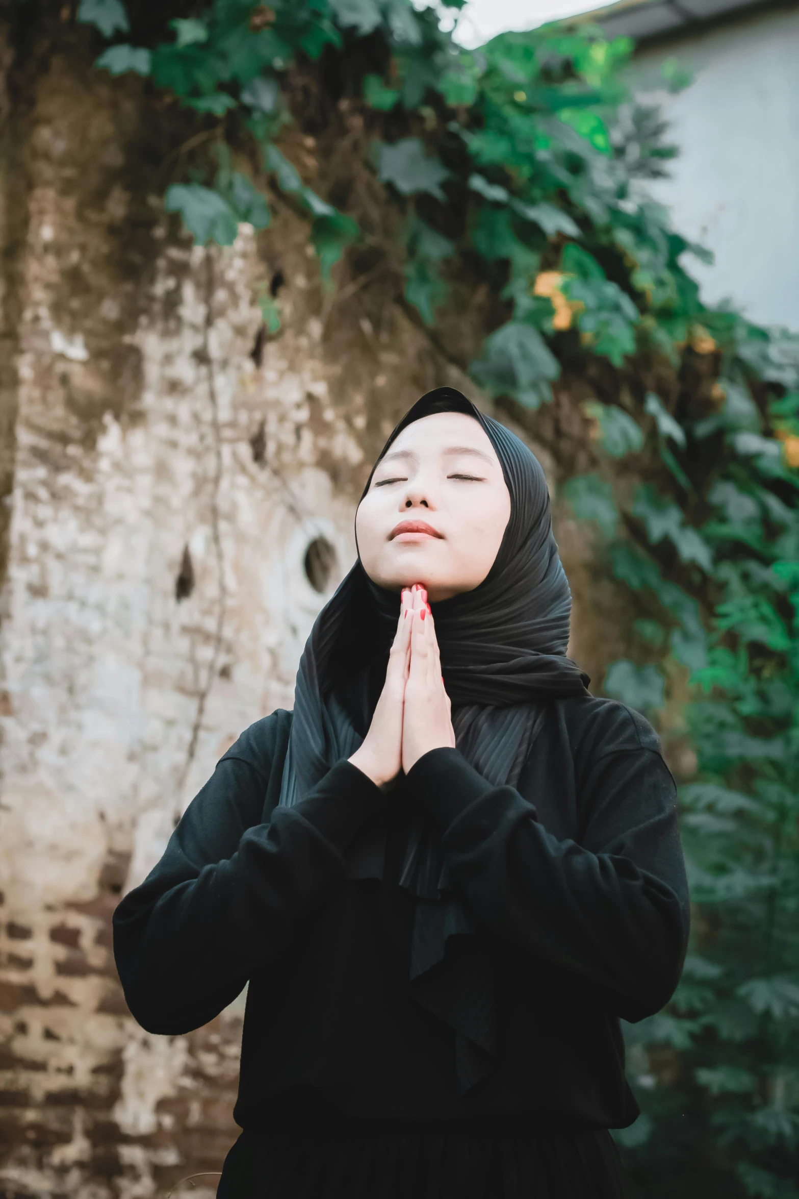 woman wearing black clothing standing in front of trees and nches