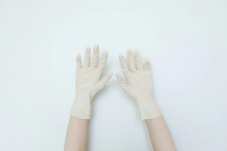 hands holding onto gloves with white background