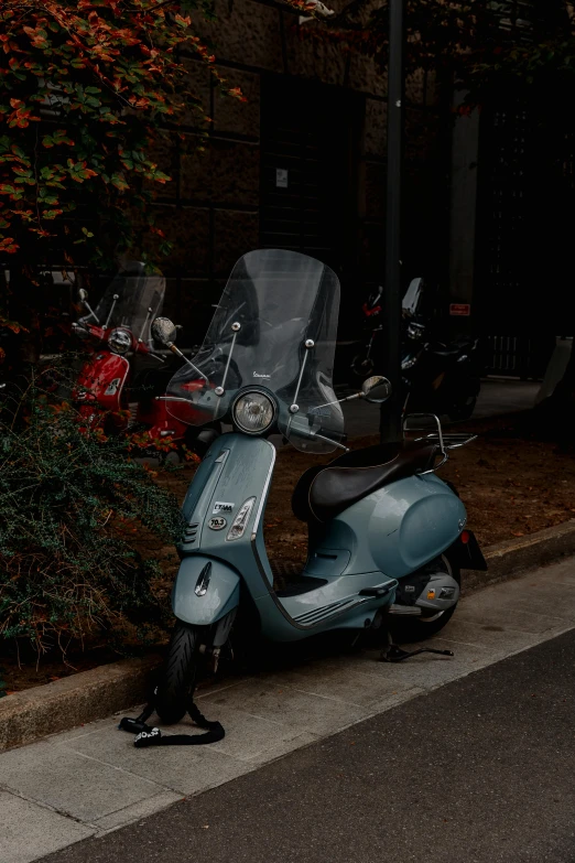 a very pretty scooter parked next to a building