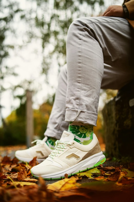 someone with green socks sitting on some leaves