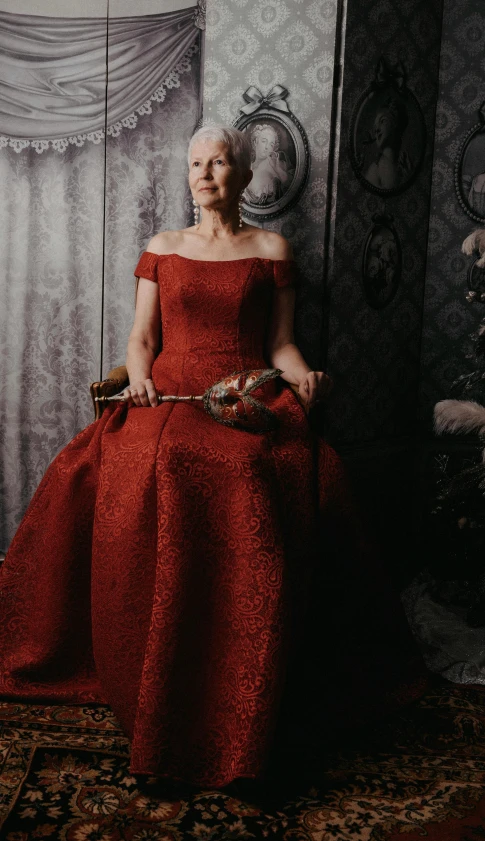 a woman in a red dress sits in a room