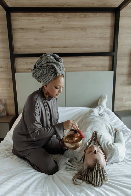 a lady sitting on top of a bed next to a dead body