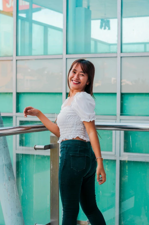 a woman standing on the edge of stairs with her hands in her pockets